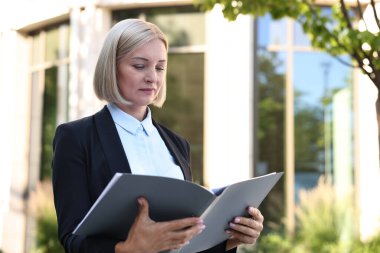 International relations. Diplomat with clipboard in suit outdoors clipart