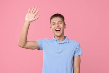 Elveda jest. Mutlu genç adam pembe arka planda sallanıyor