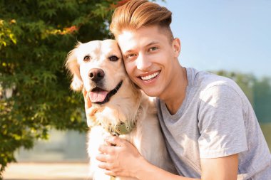 Güneşli bir günde dışarıda, sevimli Golden Retriever köpeği olan mutlu bir sahibin portresi.