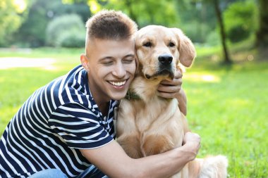 Parkta sevimli köpeğiyle genç bir adam.