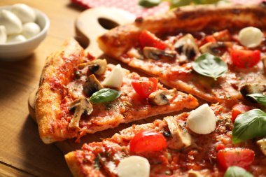 Fesleğenli, mantarlı, mozarellalı ve domatesli lezzetli pizza.