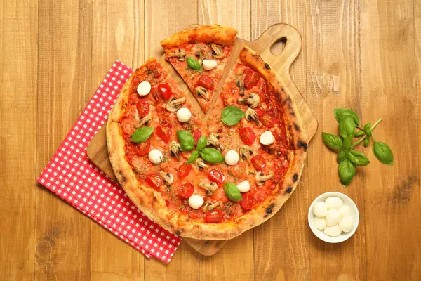 Fesleğenli, mantarlı, mozarellalı ve domatesli lezzetli pizza.