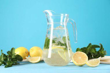 Nane şekerli limonata ve açık mavi ahşap masadaki malzemeler tazeleniyor.