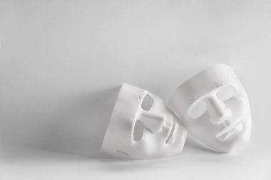 Beyaz arka planda plastik yüz maskeleri, metin için boşluk. Tiyatro performansı