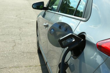 İstasyondan açık havaya modern elektrikli araba şarj ediliyor, mesaj için boşluk