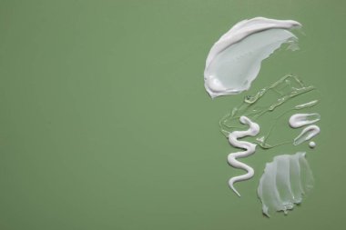 Yeşil arka planda yüz kremi ve jöle, üst manzara. Metin için boşluk