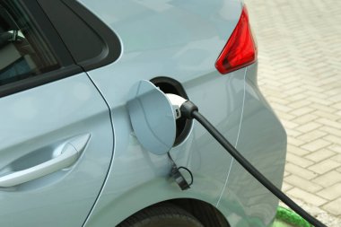 Dışarıdaki istasyondan modern elektrikli araba şarj ediliyor.