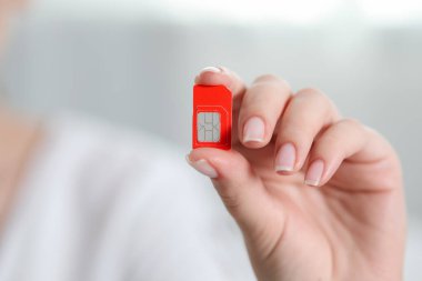 SIM kartı içeride tutan kadın, yakın plan. Metin için boşluk
