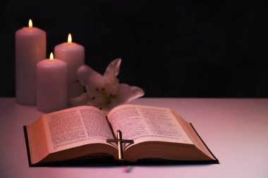 Haç, İncil, çiçek ve yanan mumlar siyah arka planda, yazı için yer var. Hıristiyanlık Dini