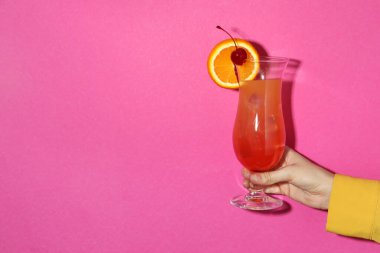 Pembe arka planda bir bardak ferahlatıcı kokteyli olan kadın, yakın plan. Metin için boşluk