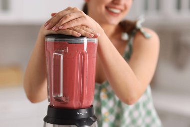 Mutfakta blender ile nefis smoothie yapan kadın, yakın plan.