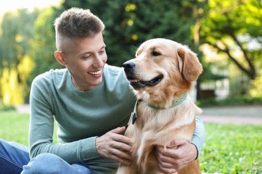 Parkta sevimli köpeğiyle genç bir adam.