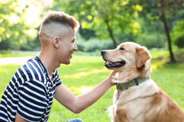 Parkta sevimli köpeğiyle genç bir adam.
