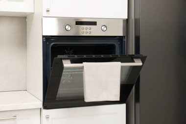 Mutfakta havluyla elektrikli fırını aç. Yemek pişirme aygıtı