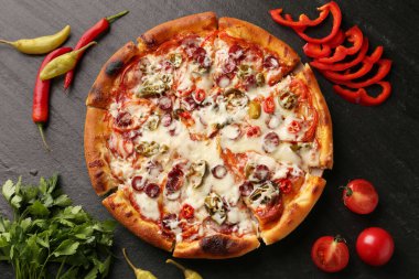 Lezzetli pizza Diablo koyu dokulu masada, düz yerde.