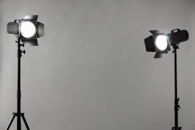 Stüdyoda gri fotoğraf ve profesyonel ışıklandırma ekipmanları