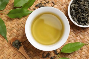 Yeşil çayı fincanda, kaşıkta ve yapraklarda serinletiyor.
