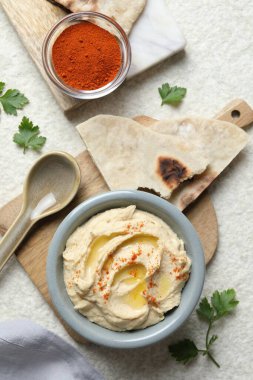 Zeytinyağı ve kırmızı biberli nefis humus beyaz desenli masada servis edilir.