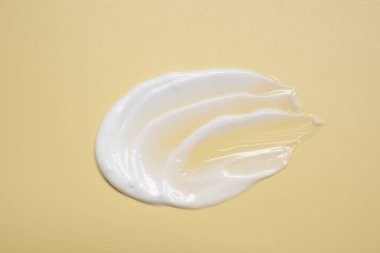Soluk sarı arka planda yüz kremi, üst manzara