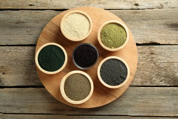 stock image Different superfood powders in bowls on wooden table, top view