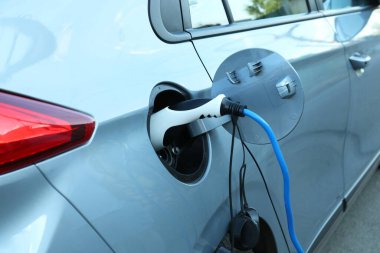 Dışarıdaki istasyondan modern elektrikli araba şarj ediliyor.