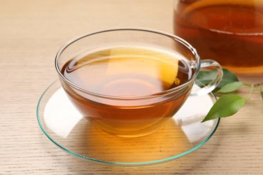 Yeşil çayı fincanda tazeleyen ve ahşap masada yapraklar, yakın plan