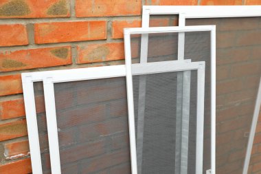 Tuğla duvarın yanındaki pencere ekranları
