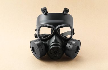 Bej arka planda bir gaz maskesi. Güvenlik ekipmanları