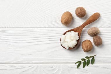 Kaşık içinde Shea yağı ve beyaz ahşap masa üzerinde fındık, üst manzara. Metin için boşluk