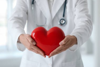Klinikte kırmızı kalpli bir doktor, yakın plan.