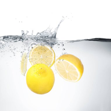 Beyaz arkaplanda suya düşen taze limonlar
