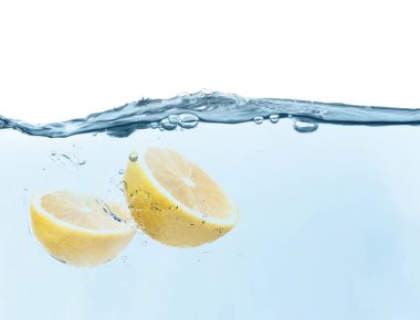Beyaz arkaplanda suya düşen limon yarıları