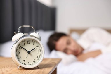Yemek saatinde yatakta uyuyan kadın, alarma odaklan.
