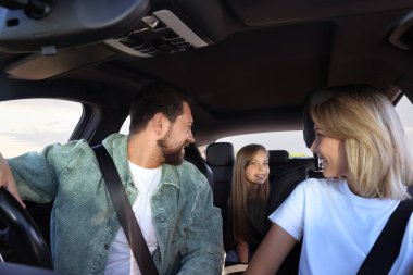 Mutlu bir aile araba yolculuğunun tadını çıkarıyor, içeriden manzaralı.