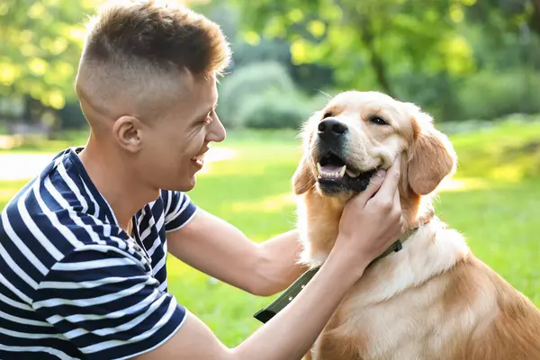 Parkta sevimli köpeğiyle genç bir adam.