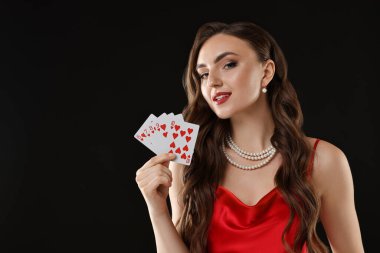 Poker oyunu. Siyah arka planda oyun kartları olan çekici bir kadın. Metin için boşluk