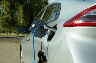 Dışarıdaki istasyondan modern elektrikli araba şarj ediliyor.