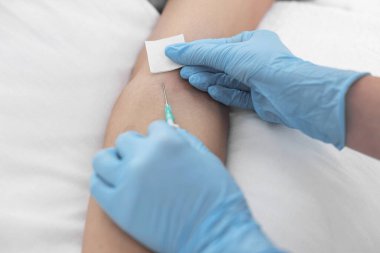 Hemşire, hastanedeki hastanın koluna serum takıyor.