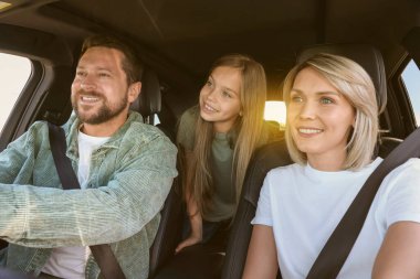 Yolculukta mutlu bir aile. Ailesi ve kızı arabada.