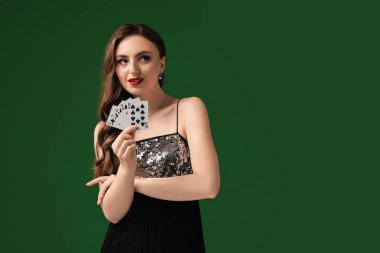 Poker oyunu. Yeşil arka planda oyun kartları olan çekici bir kadın. Metin için boşluk