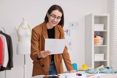 Moda tasarımcısı atölyede çizim yapıyor.