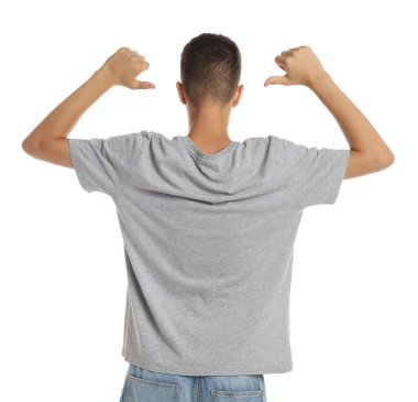 Beyaz arka planda gri tişört giyen genç çocuk.