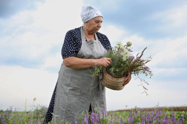 Tentür için kır çiçekleriyle kıdemli kadın.