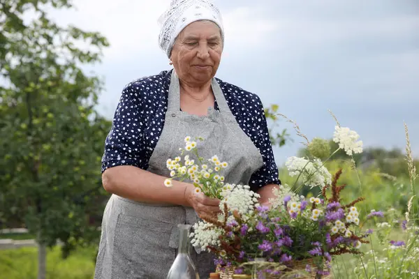 Tentür için kır çiçekleriyle kıdemli kadın.