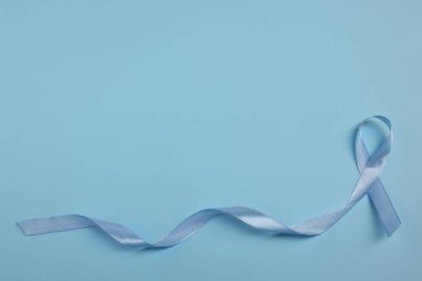 Renk arkaplan üzerinde açık mavi kurdele, metin için boşluk ile üst görünüm. Prostat kanseri farkındalığı