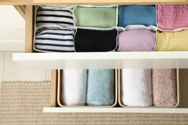 Çekmeceler farklı katlanmış kıyafetlerle, üst tarafta.