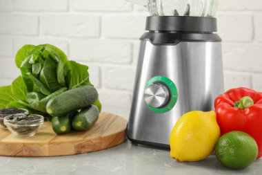 Blender ve ürünler gri masada beyaz tuğla duvara karşı, yakın plan