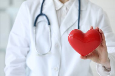 Klinikte kırmızı kalpli bir doktor, yakın plan.