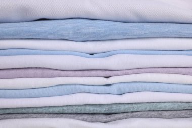 Arka plan olarak temiz renkli t-shirtler yığını, yakın plan