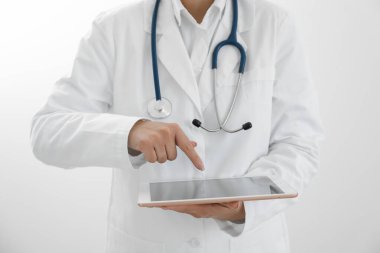 Beyaz arkaplanda tableti olan doktor, yakın plan görünümü